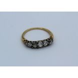 A Victorian graduated five stone diamond ring, claw set old cut diamonds with ten rose cut