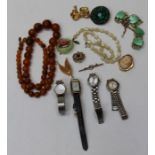 A selection of vintage costume jewellery featuring a copal bead necklace and wristwatches