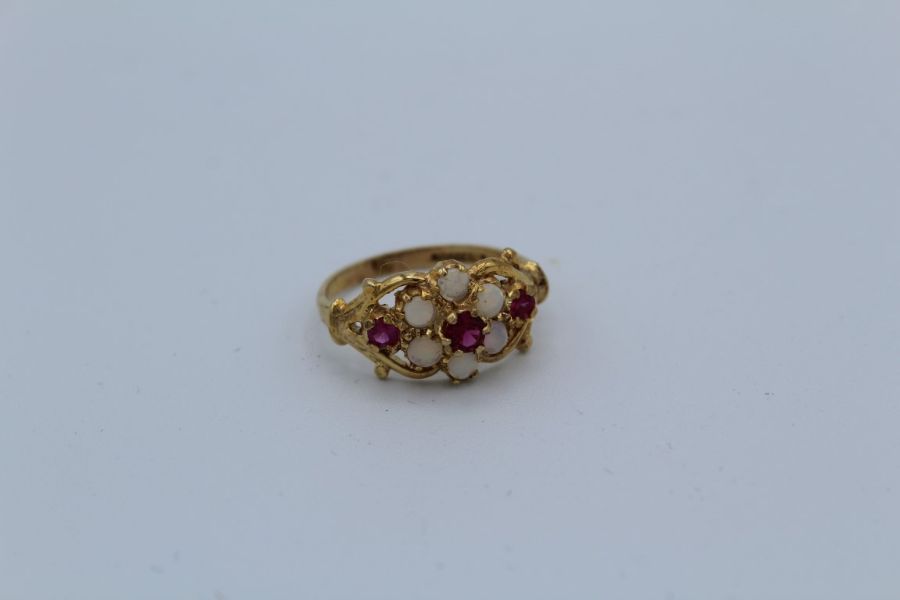 A 9ct yellow gold opal and ruby decorative cluster ring, size N. Gross weight approximately 2.5gm