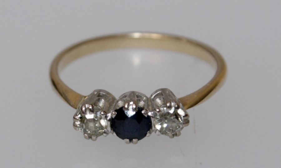 A three stone sapphire and diamond ring, round cut sapphire, flanked by two old cut diamonds,