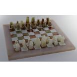 A set of mid 20th century onyx chess pieces together with a conforming board, height of King 7cm