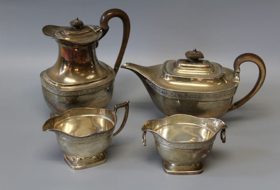 A George V Mappin & Webb four piece sterling silver footed tea set. Comprising a tea pot, water jug,