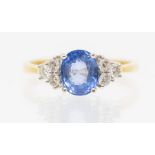 A sapphire and diamond 18ct gold cluster ring, comprising a pale blue sapphire, approx 7 x 5mm,