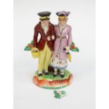 A Staffordshire pottery pearlware bocage figure of Dandies, he is carrying a basket, she an umbrella