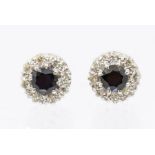 A pair of sapphire and diamond cluster earrings, comprising round mixed cut sapphires set to the