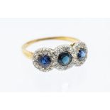 A sapphire and diamond 18ct gold cluster ring, comprising three round mixed cut sapphires each