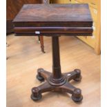 A small rose mahogany games table on four padded feet with castors, the lift-up lid reveals