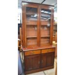 A Victorian mahogany glazed cupboard / bookcase with two glazed doors set over two drawers over