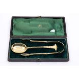 A Victorian silver gilt sugar spoon and matching sugar tongs, both with twist stems and prick dot