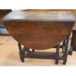 An early 20th century glazed book cabinet in oak, together with an oak barley-twist drop-leaf table