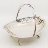 A George V silver basket, shaped oval with wire work swing handle, reticulated side panels, raised