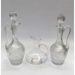A pair of cut glass claret jugs by Cumbria Crystal, complete with matched hollow blown stoppers