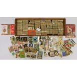 A large collection of Tea and Cigarette Cards contained within a 22cm x 61cm box. The loose cards on