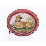 A 19th century micro mosaic oval brooch featuring a seated pug dog within a landscape, within a