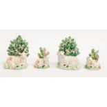 Two pairs of early Derby factory porcelain figures of sheep lying down surrounded by foliage.