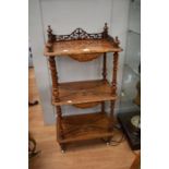 A Victorian walnut three tier inlaid whatnot with a fretwork gallery at the top and turned column