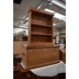 A mid 19th century pine box with carry handles, together with a pine bookcase