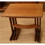 Two teak 1970s nests of three tables, one with solid and the other with smoked glaze tops
