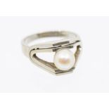 A pearl and 18ct white gold modernist ring, high mount, tension set with a round cultured pearl,