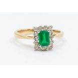 An emerald and diamond 9ct gold ring, comprising a central rectangular cut emerald approx 4 x 6mm,