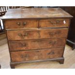 A George III chest of drawers - two drawers above three with brass swing handles, old worm and