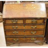 A small oak George III bureau, having drop-down writing slope above two small drawers and three long