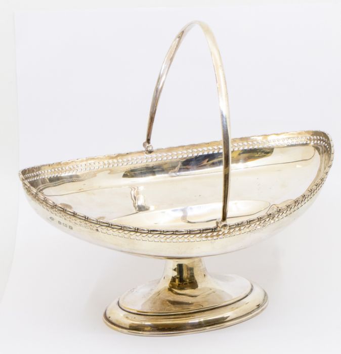 A George V silver swing handle bread basket, with pierced work and engraved inscription "Presented