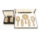 A cased silver vanity set including; Mirror, two hand brushes and two clothes brushes, hallmarked