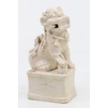 A 19th century Chinese porcelain dog on a plinth