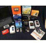 A collection of used mobile phones from the 1990s, iphones, Nokias, Samsung; Olympus digital