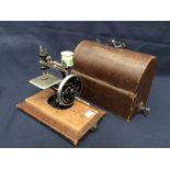 An early 20th century miniature Singer sewing machine - 'Singer Man FG and Co' with original case.