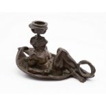 A 19th century classical bronze chamberstick in the shape of Satan lying on his fallen angel wings