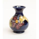 A Moorcroft Pottery Clematis design blue ground vase
