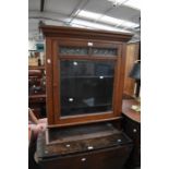 A late 19th century display cabinet in mahogany with leaded glass detail to the top of single door