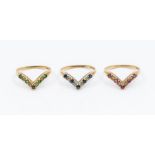 A collection of three 9ct gold coloured gem diamond set wishbone rings including a ruby, sapphire