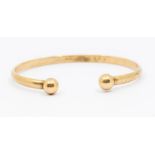 A 9ct gold torque bangle D section with ball bead terminals, width approx 5mm, internal diameter