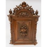 A carved wood wall-mounted cabinet with six drawers. Carved fruit detail.