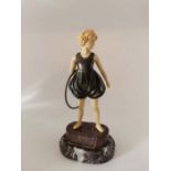 A mid to late 20th century Bronze and resin girl holding a hoop stood on a serpentine base. 23cm