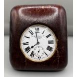 A leather cased pocket watch/travel clock by Barraclough. Winds and appears to run. White dial