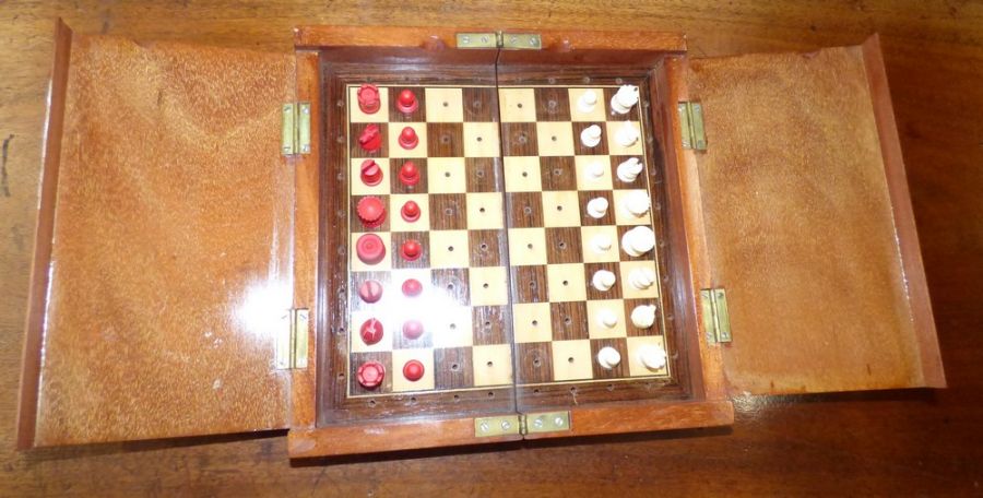 A complete boxed travel fold away chess set, plastic pieces, measures 50cm x 25 cm when unfolded,