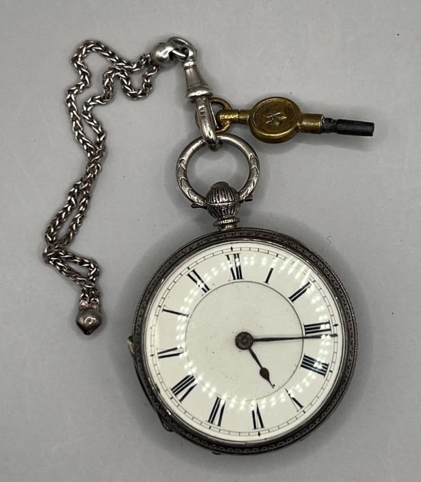 A sterling silver key wound pocket watch in ornamental case decorated with forget me nots and