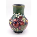 A Moorcroft 'Iris' pattern vase on as green ground. Height approx. 25cm. Impressed Moorcroft, Made