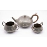 An antique Walker and Co 'Homeland' hand beaten pewter tea set, comprising of tea pot with wooden