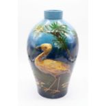 Burmantofts: An art pottery baluster vase decorated with a layered heron and detailed foliage