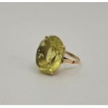 A 14ct. gold and pale peridot dress ring, claw set large mixed oval cut pale green peridot, size