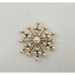 A 14ct. yellow gold and cultured pearl set star brooch, having central cultured pearl with radiating