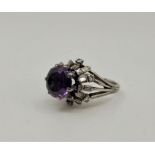 A platinum, diamond and purple-blue sapphire cluster ring, claw set round mixed cut purple-blue