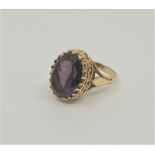 A 14ct. gold and amethyst cocktail ring, having oval coronet style mount set mixed oval cut