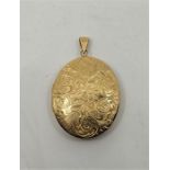 A 9ct. gold oval locket, Birmingham 1973, engraved floral scrolls to one side and plain polished