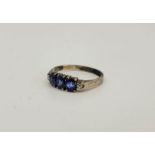 A white metal, sapphire and diamond ring, set row of three graduated sapphires flanked by single